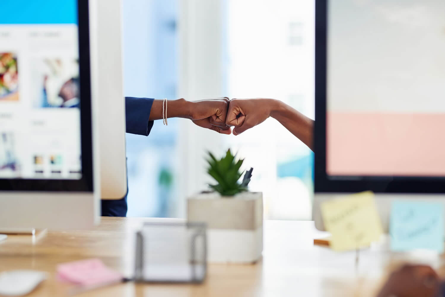 Teammates fist bumping_iStock-1151370282