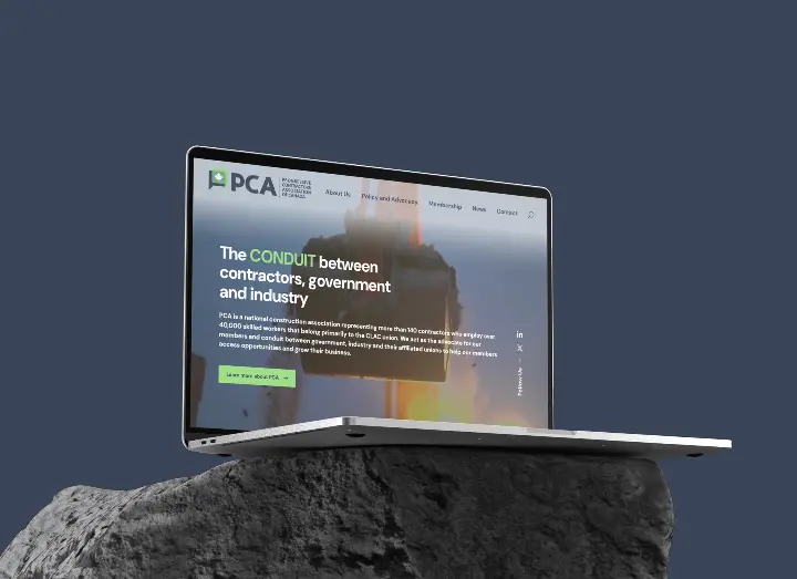 Laptop showing PCA's website, laptop is on a rock.