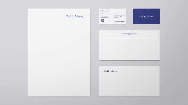 Torkin Manes stationery laying flat, business card, letterhead, and envelope
